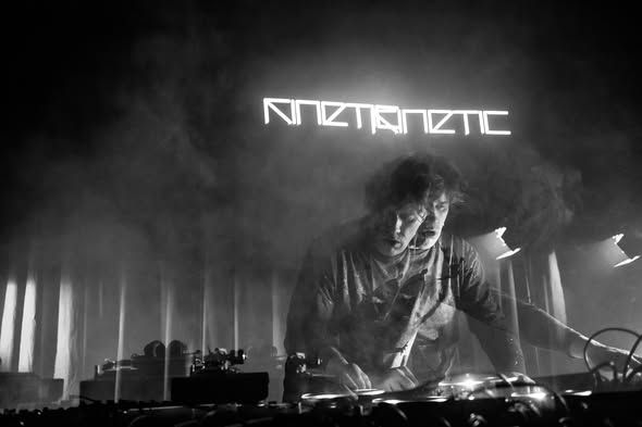 A DJ playing under the KINETIC neon sign
