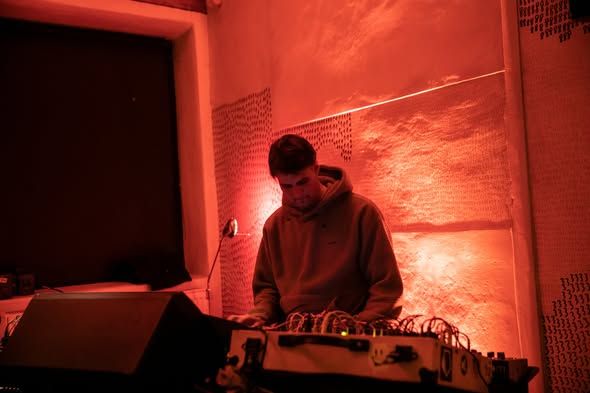 A performer at the gear table in red light