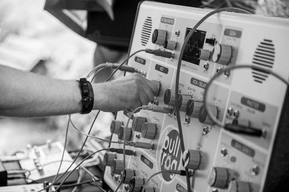 Hands patching cables on a synthesizer